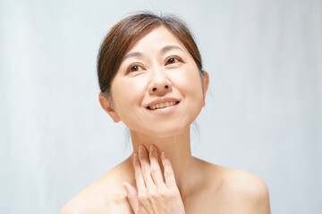 首元に手をやる笑顔の中年女性