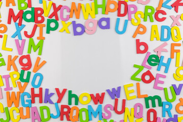 Colorful alphabet magnets on whiteboard framing copy space