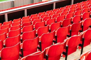 red plastic chair in football, basketball or baseball arena stadium in a row for visitor to visit and enjoy sport match competition for big football match in football stadium