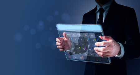 A man His hand is holding a visual Appointment Reminder for the Calendar as well as the Organizer's Agenda. Event planners use timetables to organize events.