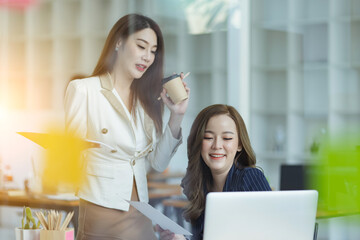 Asian business woman working with paper note on glass wall, Business people meeting to share idea at office, Business planning and Sticky note on glass wall.