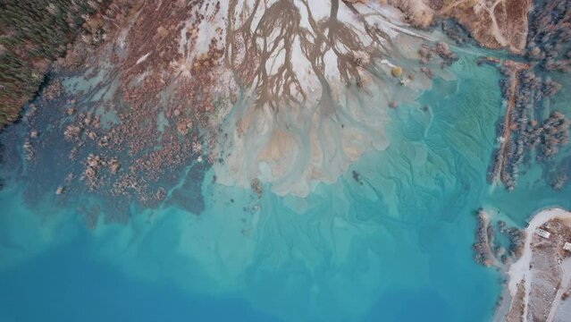 Divorces from rivers flowing into a mountain lake. It was as if the surface of the water was painted with watercolor from turquoise to dark blue gradient. There are autumn trees Top view of Lake Issyk