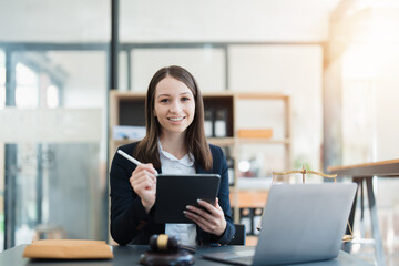 Portrait of a Asian woman lawyer studying lawsuit a for a client using tablet computer  to work before going to court.