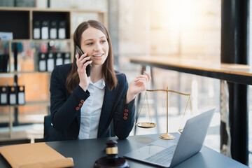 Portrait of a Asian woman lawyer studying lawsuit a for a client using smartphone , documents and...