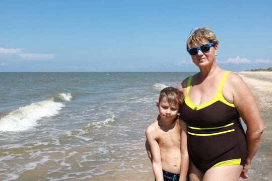 Grandmother with grandson on beach of Sea of Azov