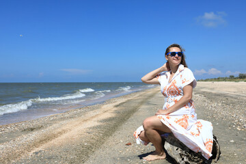 Fototapeta na wymiar Woman sitting on beach of Sea of Azov