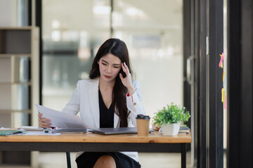 Asian businesswoman are stressed and tired from work sitting at desk in the office, feeling sick at work, stress from work.	