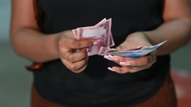 Closeup of a nigerian business lady counting the new naira note. 1000naira, 500naira and 200 naira