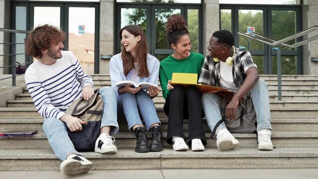 Young students smiling sitting on University stairs. College students happy together after class 