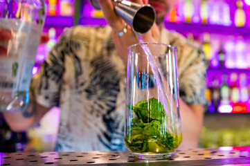 bartender preparing mojito cocktail drink in bar