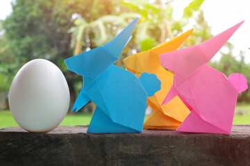 Colorful and cute rabbit bunny paper origami with egg in garden. Happy Easter celebration concept.
