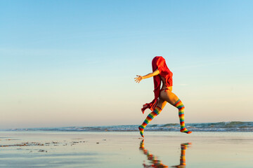 girl running free to the sea in rainbow tights