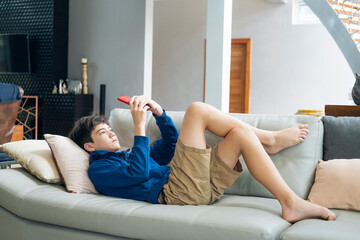 The boy playing online game on smartphone at home
