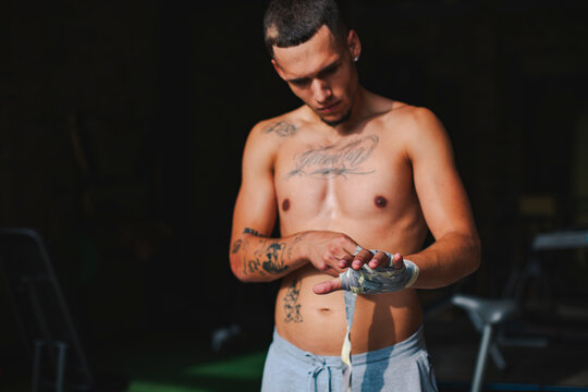 Latino boy putting bandages on his hands before a boxing match