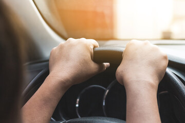 Close up view of woman holding steering wheel driving a car