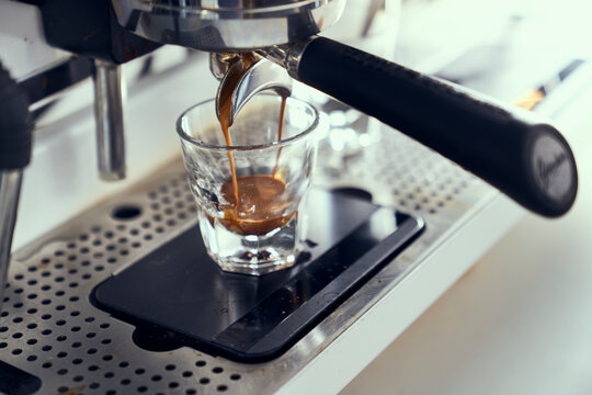 A single espresso shot being pulled from an espresso machine.