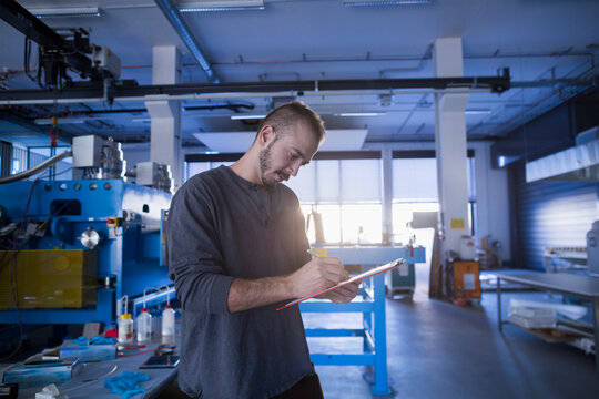 Young male engineer working in an industrial plant, Freiburg im Breisgau, Baden-W&uuml;rttemberg, Germany