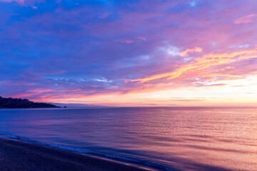 view at sunrise or sunset in sea with nice beach , surf , calm water and beautiful clouds on a background of a sea landscape