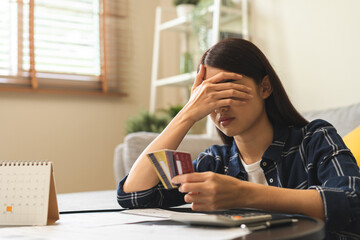 Business financial concept, owe asian young woman, female sitting cover face with hands, stressed by calculate expense from invoice or bill, have no money to pay mortgage or loan. Debt, bankruptcy. - obrazy, fototapety, plakaty