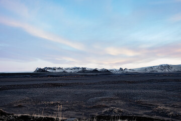 Iceland volcanic landscape sunset or sunrise over snow puffered mountains