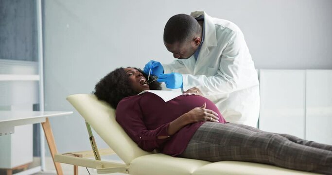 Dentist Treating Teeth Of Young Pregnant Woman Patient Lying