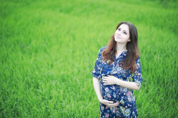 Fototapeta na wymiar Pregnant girl in a dress in nature