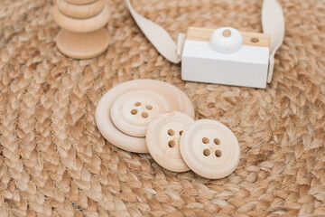 Obraz na płótnie Canvas wooden children's toys on the background of a wicker carpet in the baby. Wooden buttons. environmental toys for baby development