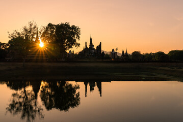 Sukhothai Historical Park with Reflection of Ancient Buddha Statue in Water at Sunset