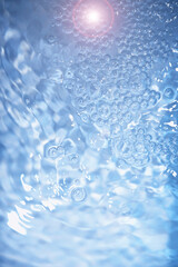 Bubbles and seething water in the light of sunlight.Blue water texture.