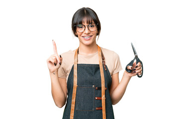 Young caucasian seamstress over isolated on chroma key background showing and lifting a finger in sign of the best