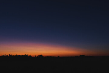 Morgendämmerung mit Silhouette von Wald und Häusern