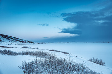 Iceland winter panorama landscape with snow and blue cloudy sky at sunset 
