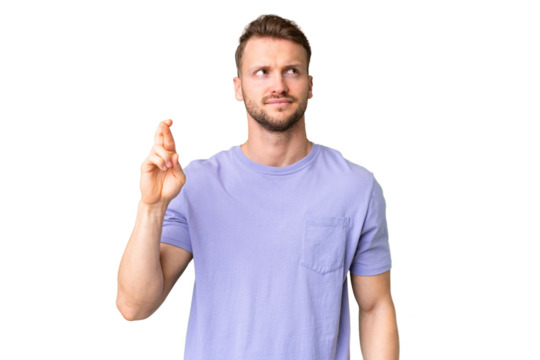Young handsome caucasian man over isolated chroma key background with fingers crossing and wishing the best