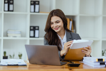 Businesswoman working with laptop and document paper sitting at desk in office workplace, business finance and accounting, business online training concept.