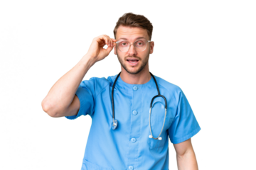 Young nurse man over isolated chroma key background with glasses and surprised