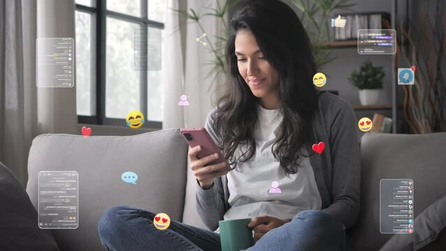Young woman on couch uses smartphone,graphic representation of social media emoticons ,posts,likes,smiley faces flying around device,3d icons animation visualization