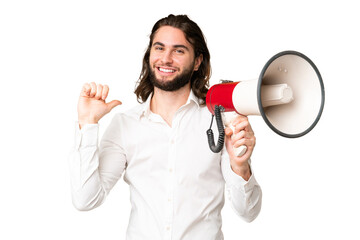 Young handsome man over isolated chroma key background holding a megaphone and proud and self-satisfied