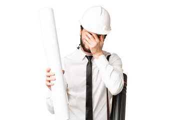 Young architect man with helmet and holding blueprints over isolated chroma key background with...