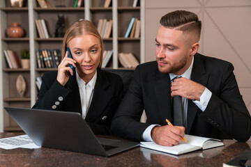 Smiling businesswoman call and businessman taking notes in office room