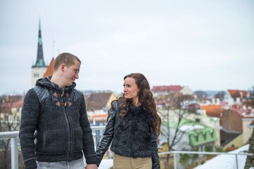 Tallinn tourists smiling and holding hands. Beautiful couple walking in Tallinn Old town at winter