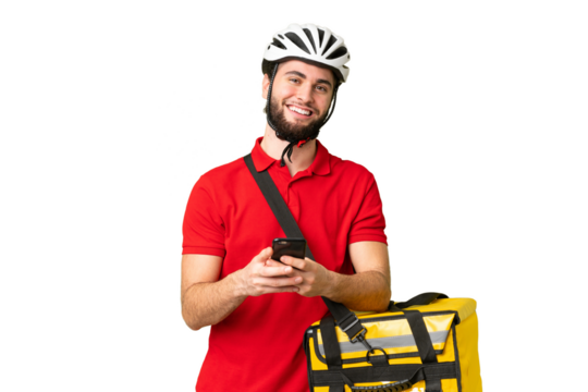 Young delivery man with thermal backpack over isolated chroma key background sending a message with the mobile - Powered by Adobe