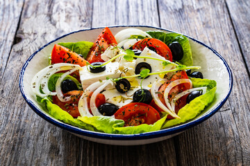 Fresh vegetable salad with feta cheese on wooden table
