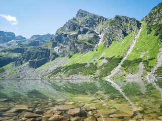 Prominent rocky mountain reflecting in crystal clear alpine lake, Poland, EU