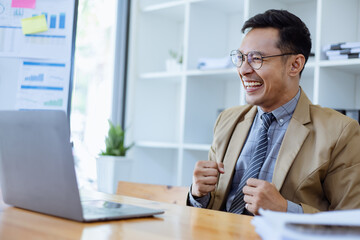 Happy Asian man working online sitting at desk in office, freelance business, Asian man happy and smile face.