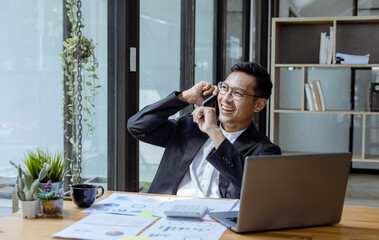 Happy Asian man working online sitting at desk in office, freelance business, Asian man happy and smile face.