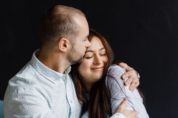 man and a woman in love pose for a family portrait, hugging