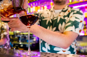 man hand bartender making cocktail in glass on the bar counter