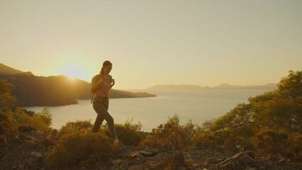 Young woman hiking in mountains at sunset. Tourist traveler with backpack on hike