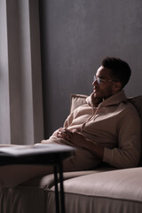 Fototapeta premium Portrait of a cheerful young african american man 20s wearing casual hoody and glasses against black background. copy space isolated