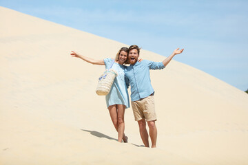 open armed couple on a sand dune